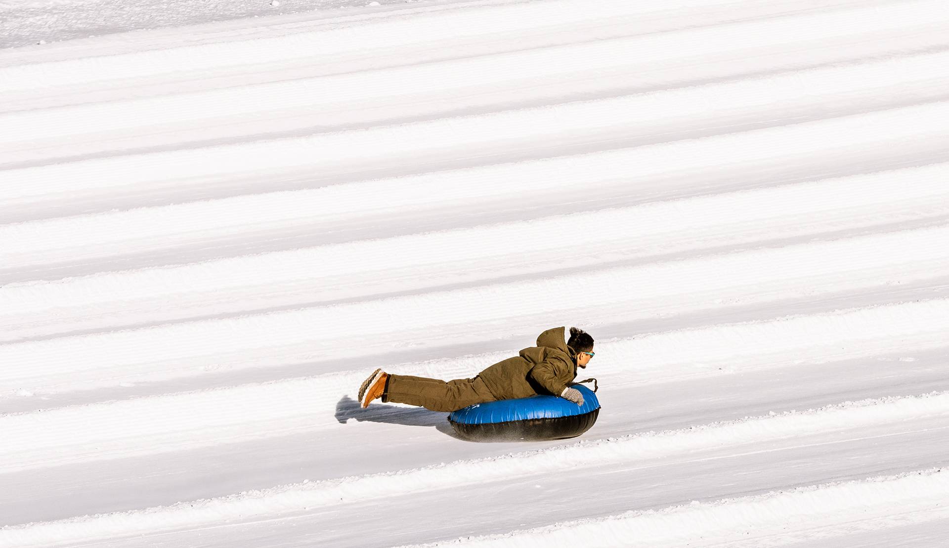 someone riding a snow tube smiling