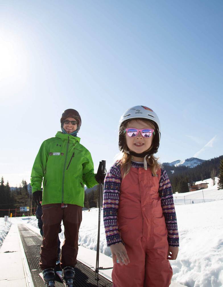 lesson kid smiling on magic carpet with instructor in background