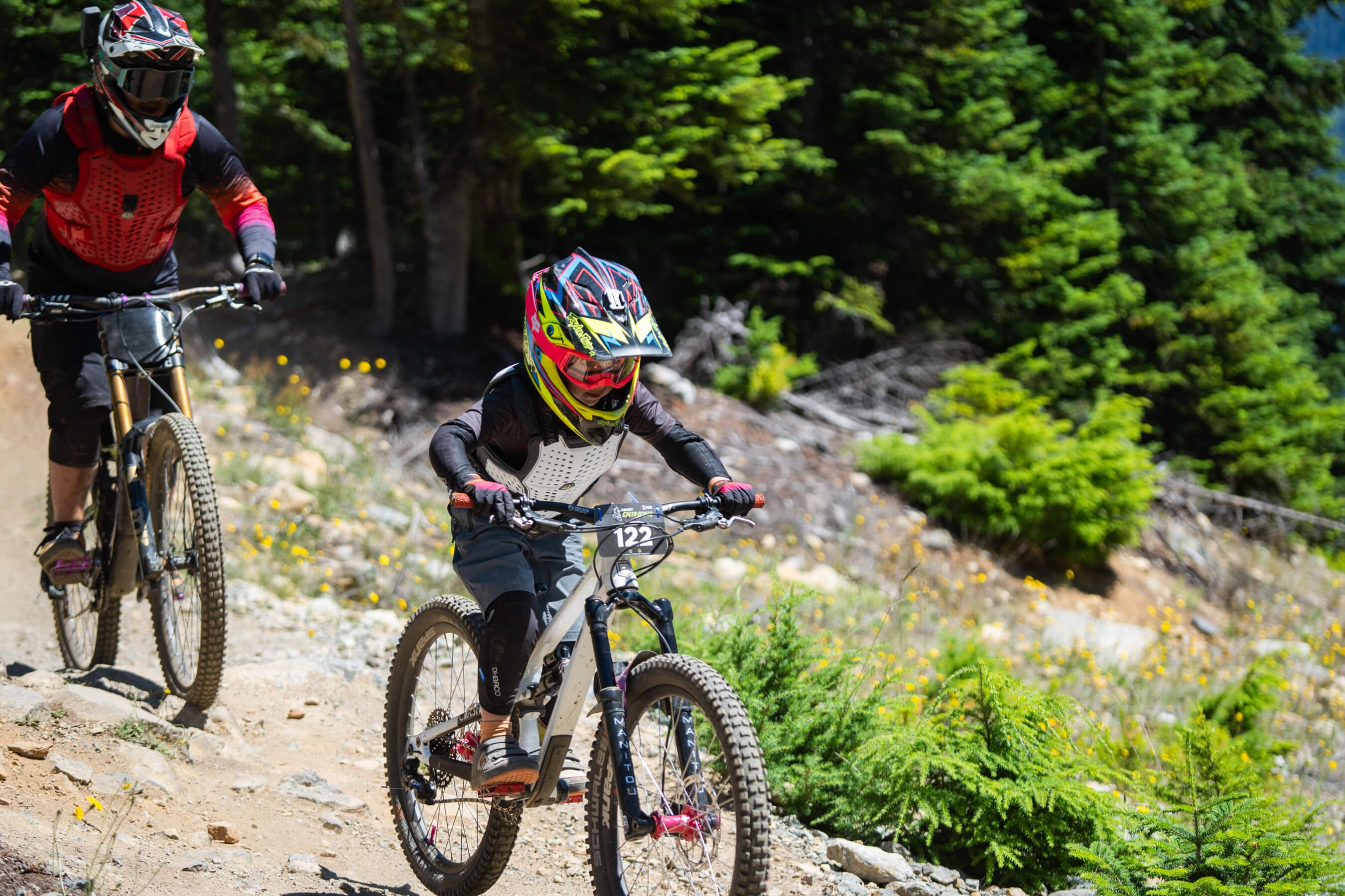 Parent follows as youth competitor speeds through bike race course