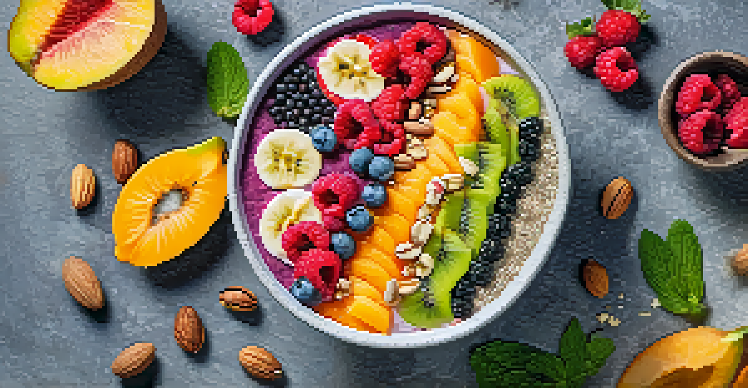An overhead view of a colorful smoothie bowl decorated with fruits, nuts, and seeds on a textured stone surface.