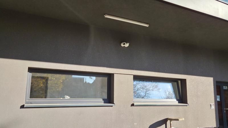 Kamera monitoringu zamontowana na elewacji budynku nad oknami i wejściem, Systemy monitoringu Łódź