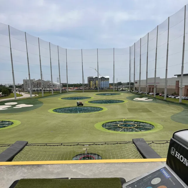 Topgolf driving bays viewed from a hitting station.