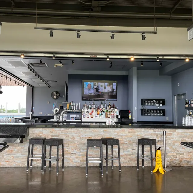 An empty Topgolf bar and service counter overlooking the driving range.