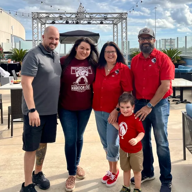 A family group poses together on the Topgolf patio.