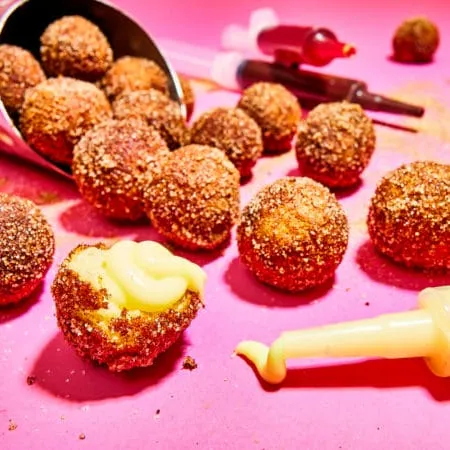 Filled doughnut bites served with dipping sauces.