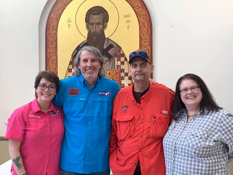 Four Gene Potts Memorial supporters pose together beneath a religious icon.