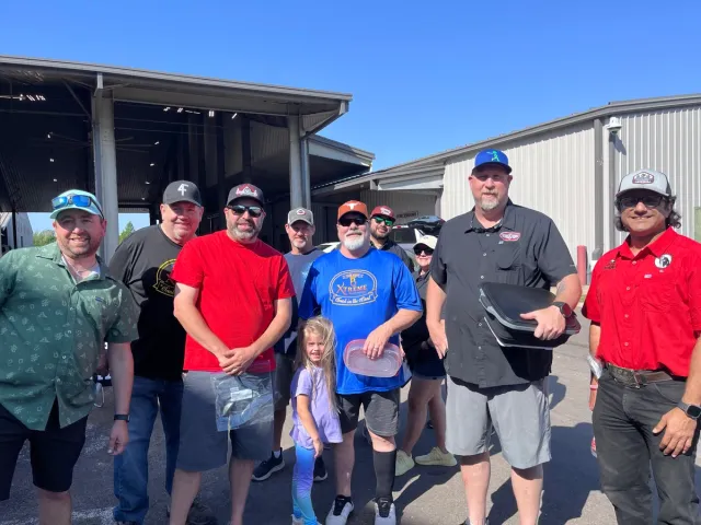 Cooking team members pose outside the expo building at the Gene Potts Memorial cookoff.