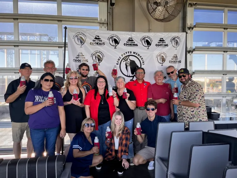 Gene Potts Memorial supporters pose together inside a Topgolf venue.