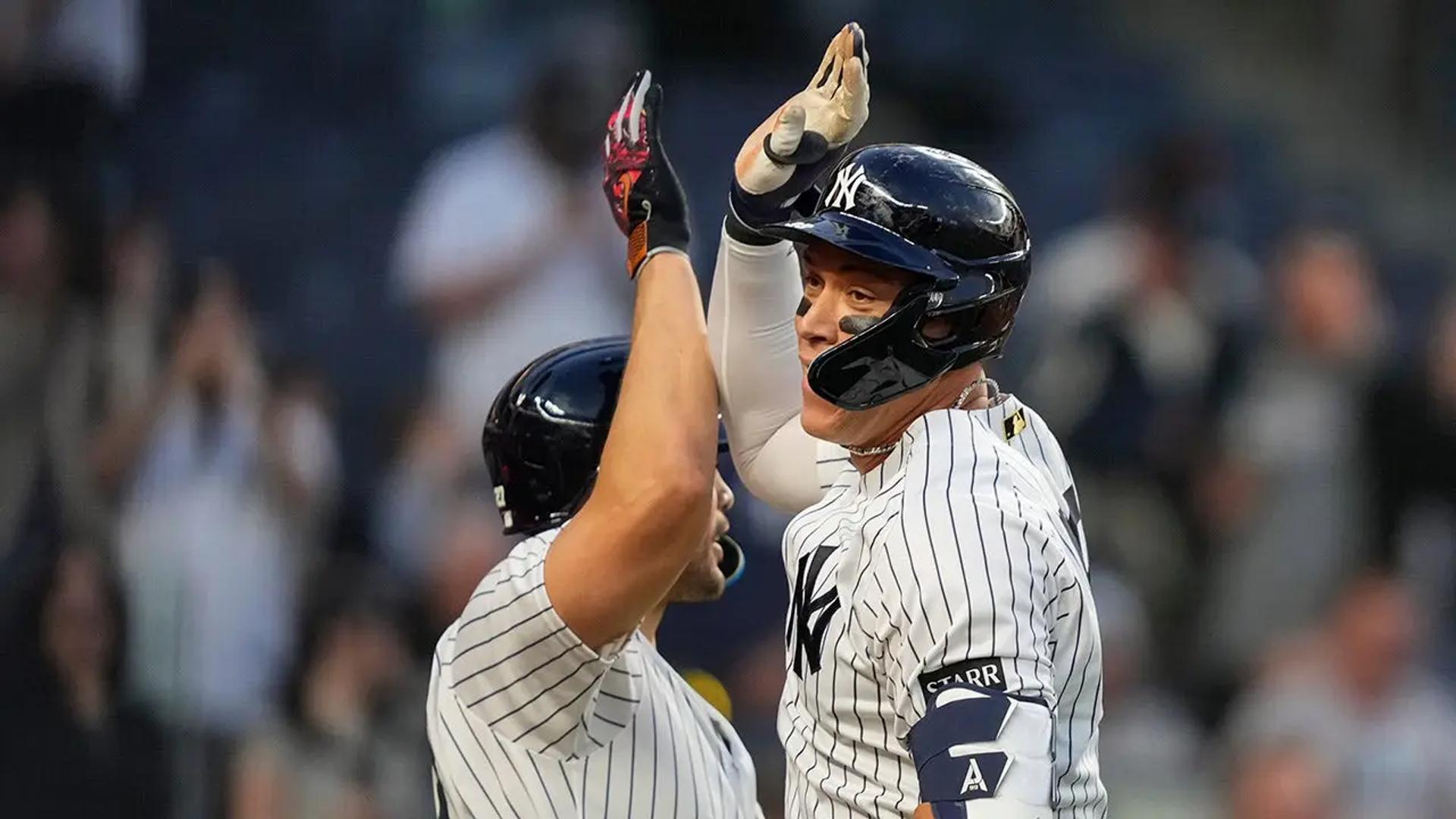 Aaron Judge celebrates at home plate as Trent Grisham rounds the bases after his ninth-inning game-tying home run against the Angels at Yankee Stadium.