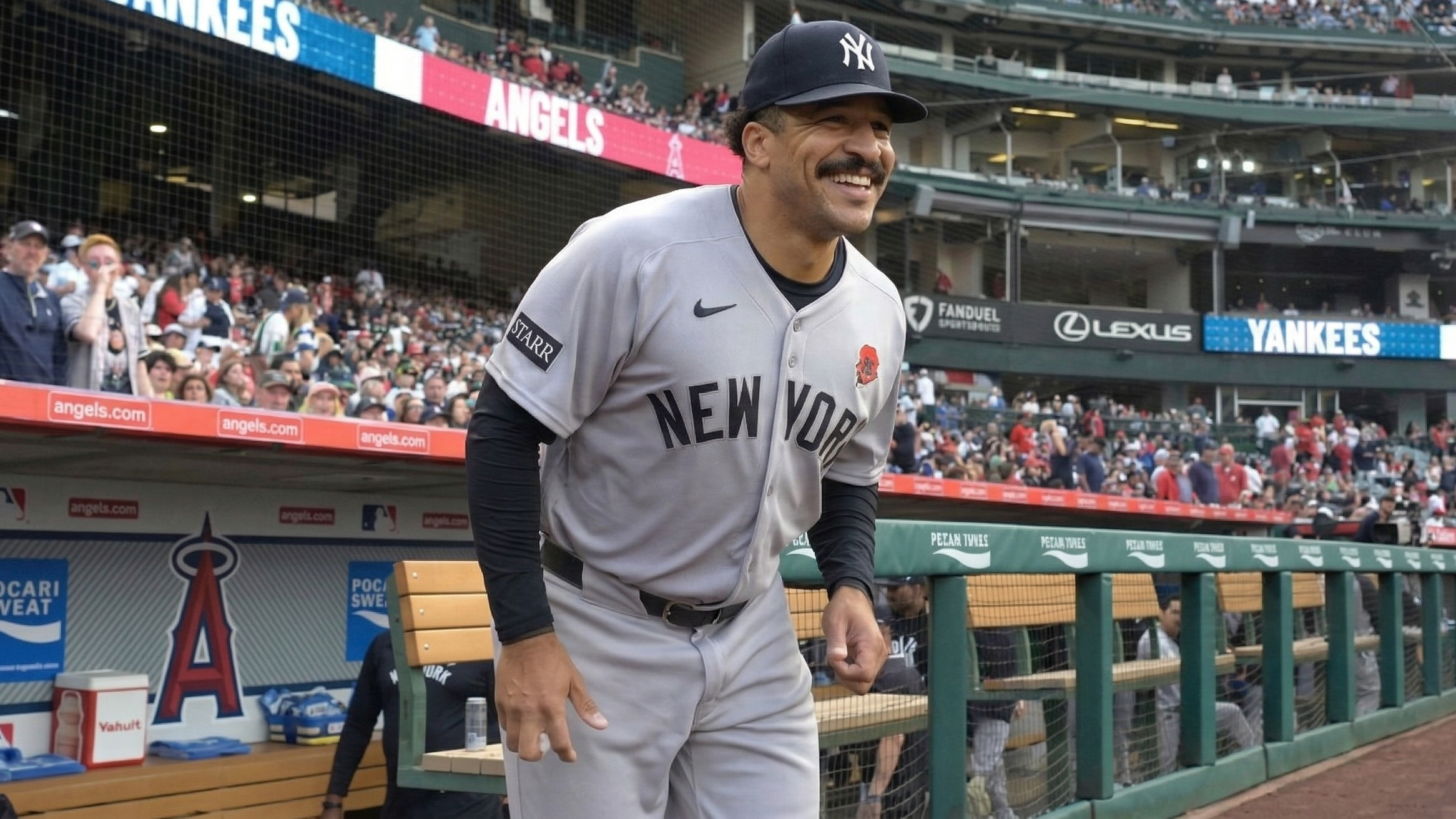 Trent Grisham tracks a fly ball in center field at Yankee Stadium as fans look on.