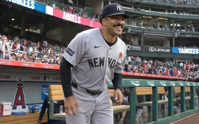 Trent Grisham tracks a fly ball in center field at Yankee Stadium as fans look on.