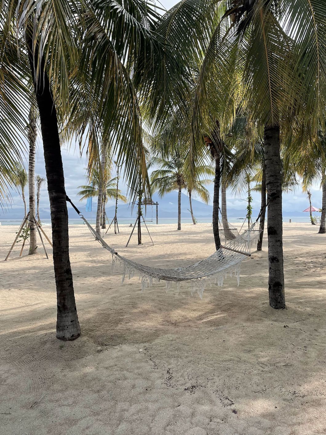 a woman is sitting in a lotus position on a wooden deck at sunset .
