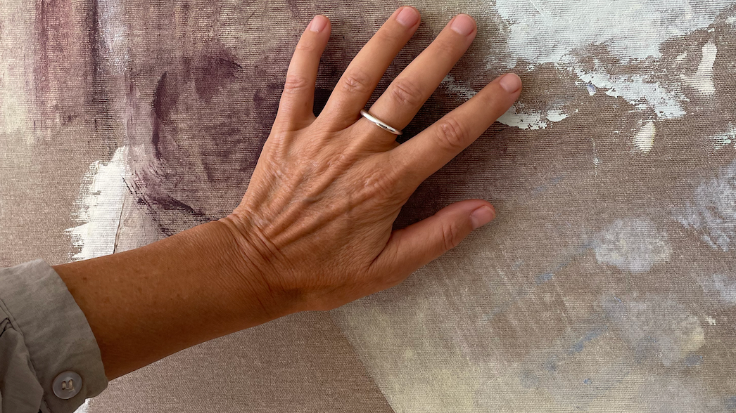 a woman is sitting in a lotus position holding a singing bowl .