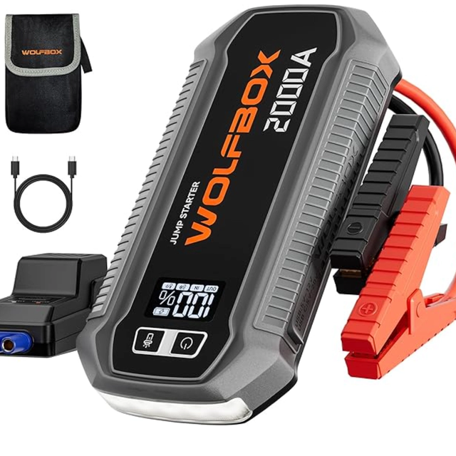 WOLFBOX 2000A jump starter power pack with LCD display, jump leads, USB charging ports and emergency LED light.