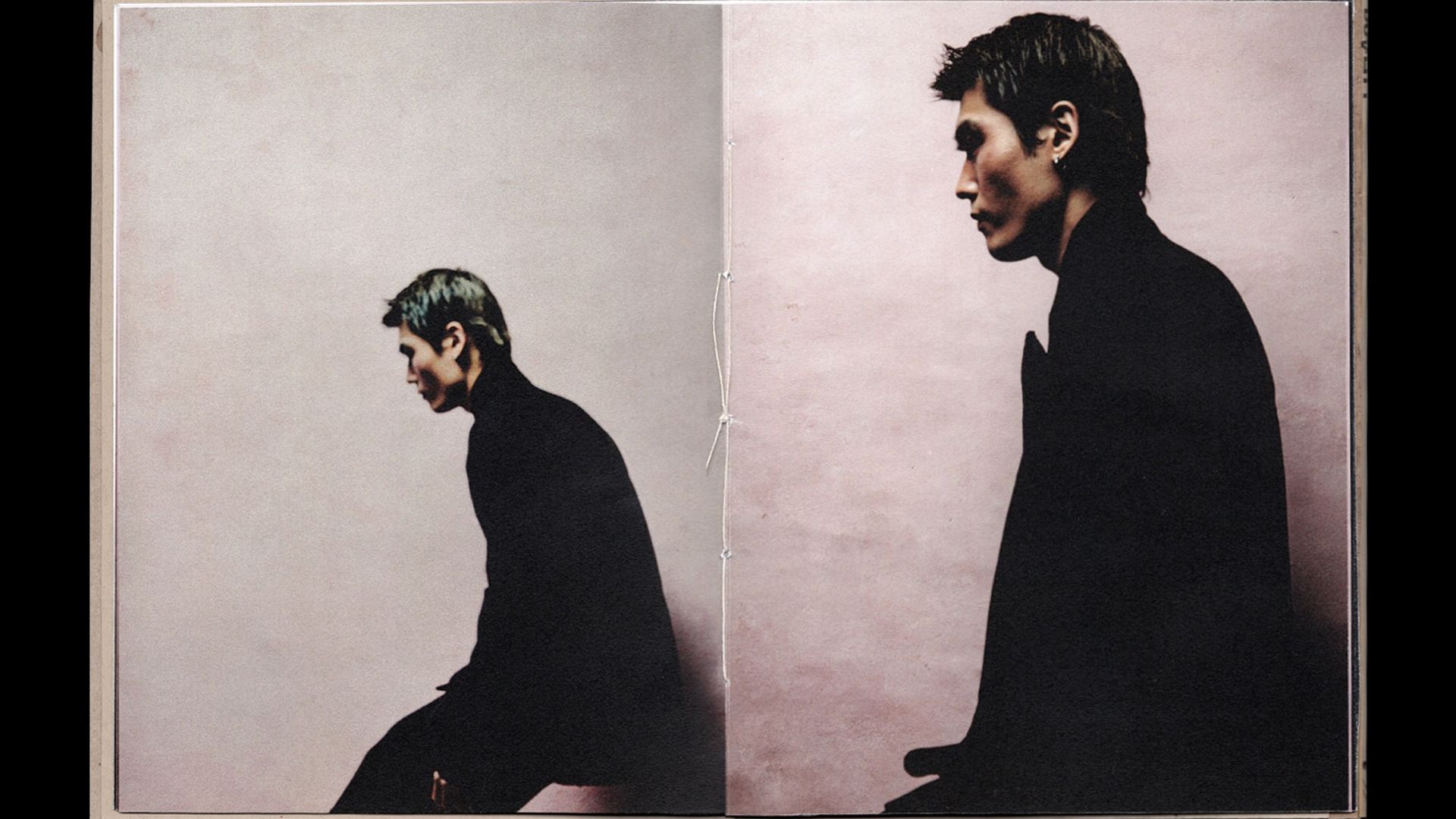Two side by side images of a young man in all black, one sitting one standing, bound like a book in between the images
