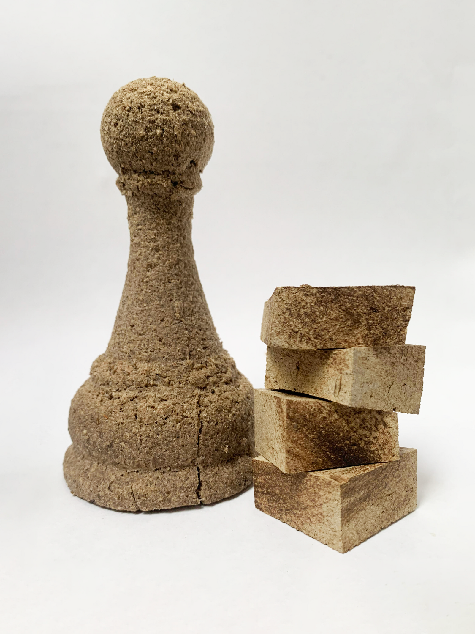Image of a moulded chess piece using a biomaterial, and cut sections