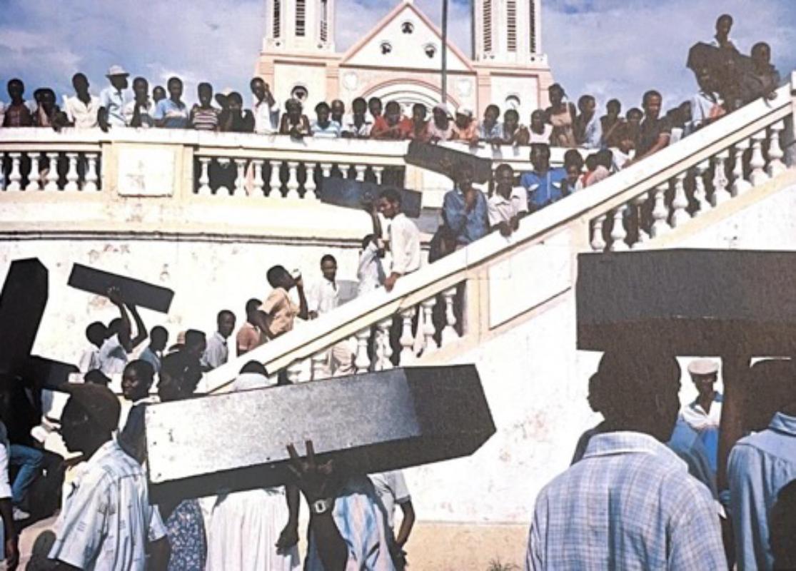 Grainy image of Haitians stood on steps carrying small coffins