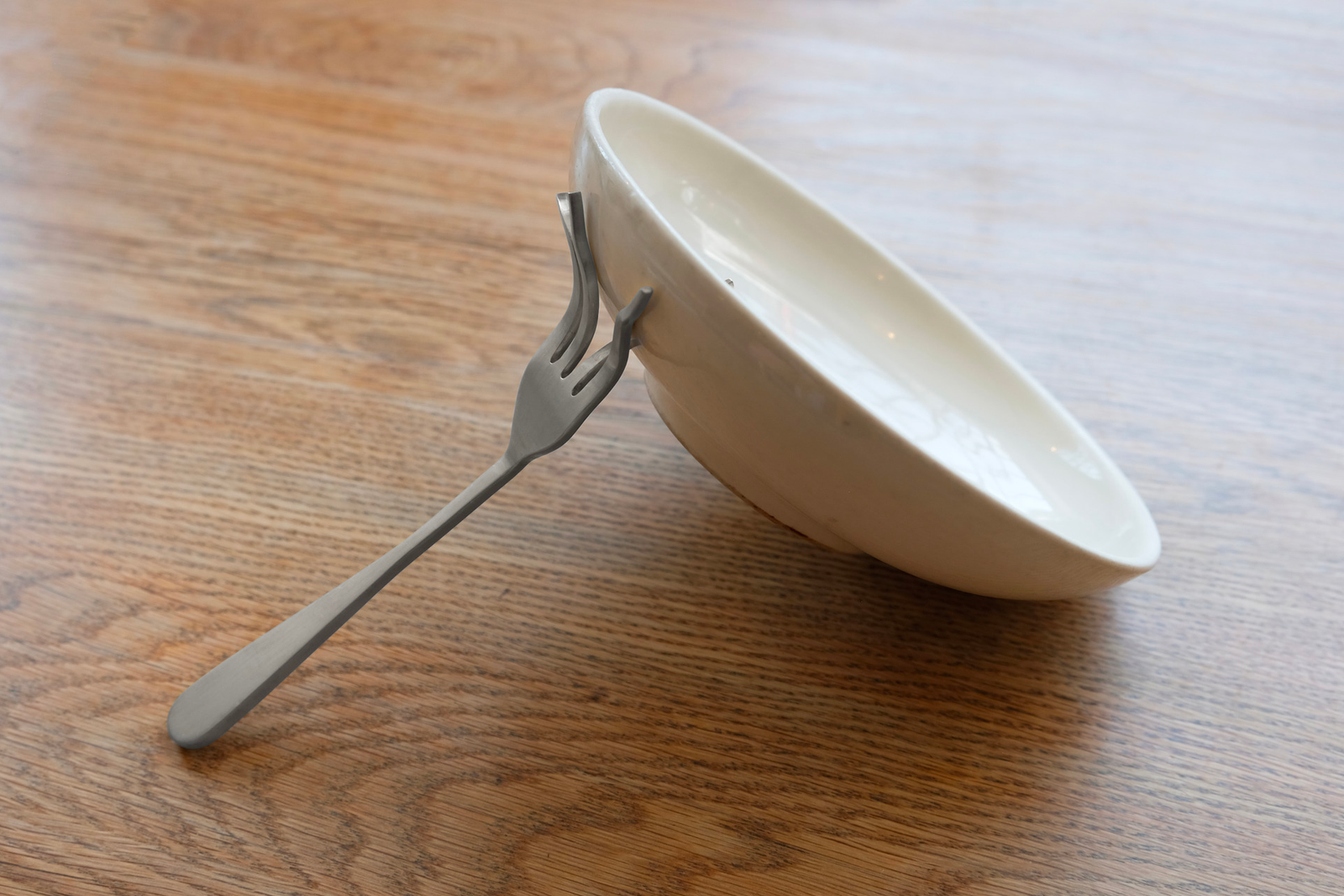 a fork crashing into a bowl from the side