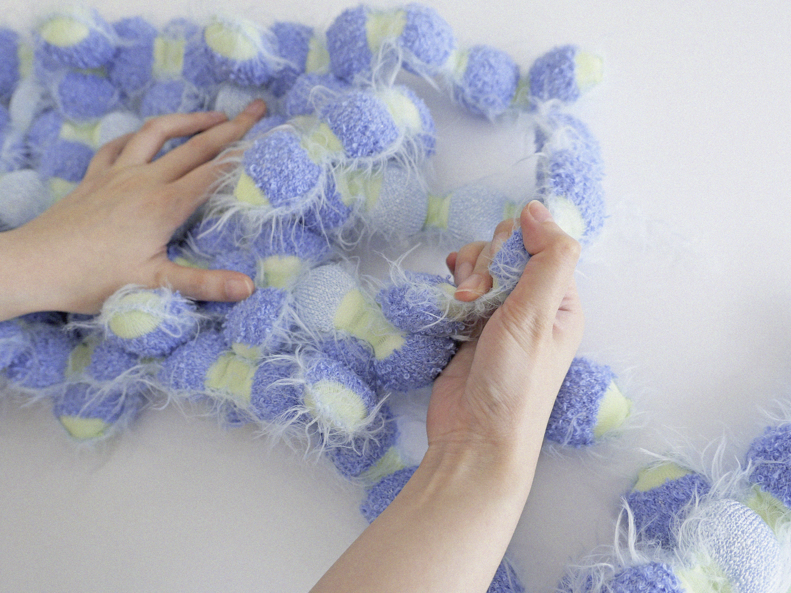 Hands interacting with "Assembly & Sensory" Textiles