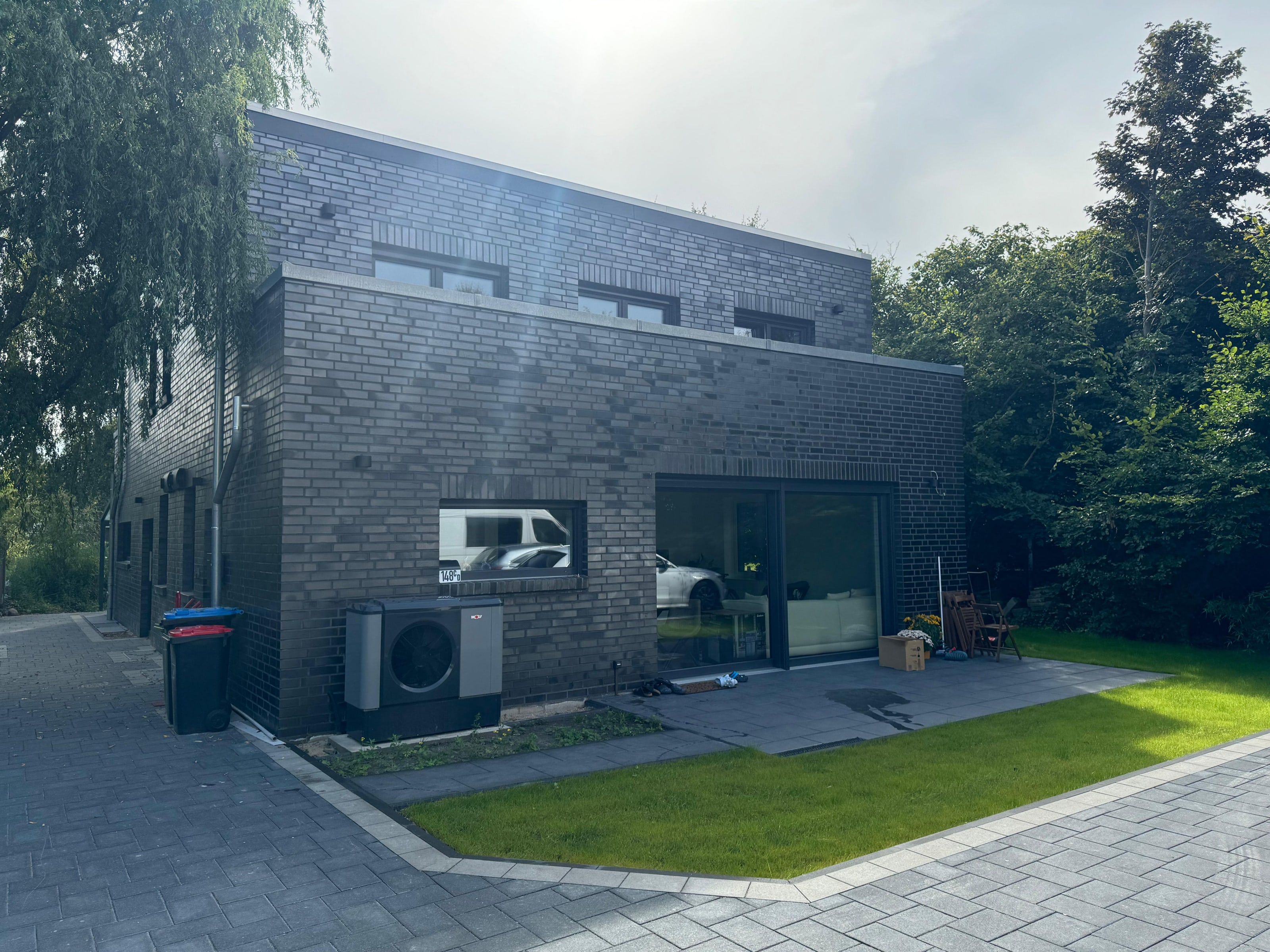 Doppelhaus mit dunkler Klinkerfassade und Flachdach, Gartenseite