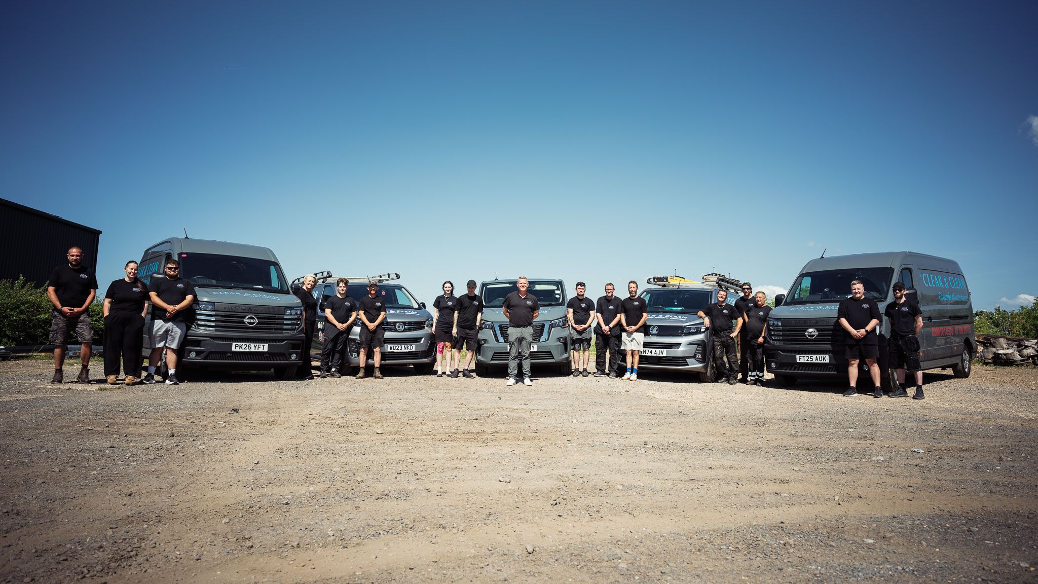 The full Clear & Clean team standing in front of their branded fleet of five vans