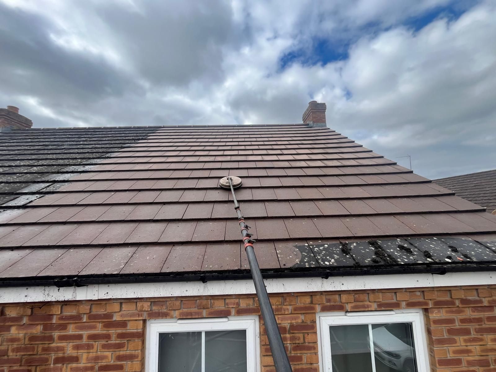 Clear & Clean operative using specialist steam cleaning equipment to safely remove moss, algae, and dirt from a commercial block roof, restoring the surface and improving the appearance of the property.