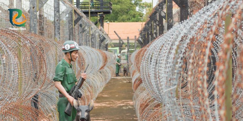 A historical guard mannequin beside the prison barbed-wire display