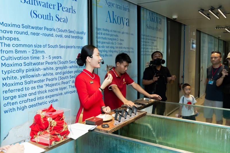 A presenter and visitors at a pearl demonstration counter