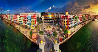 Colourful canal-side buildings and a pedestrian bridge at Grand World