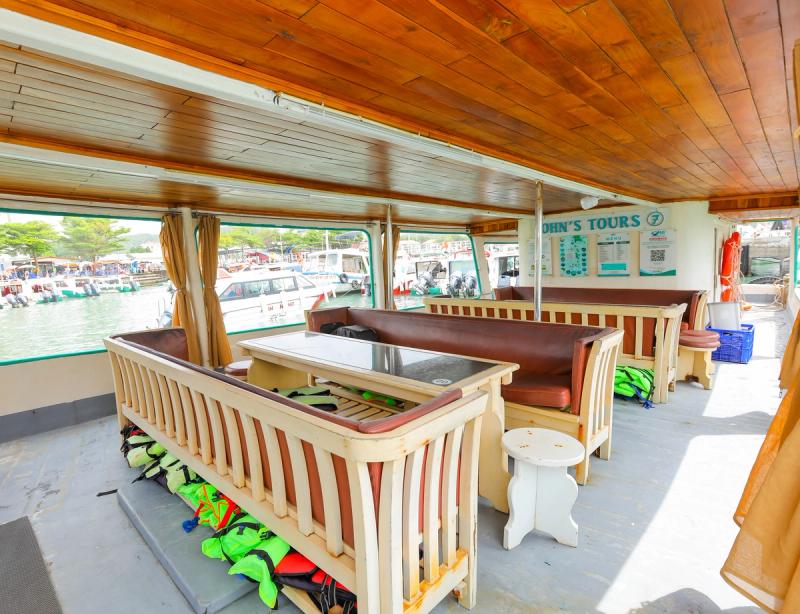 Wooden benches and a covered passenger area inside a tour boat