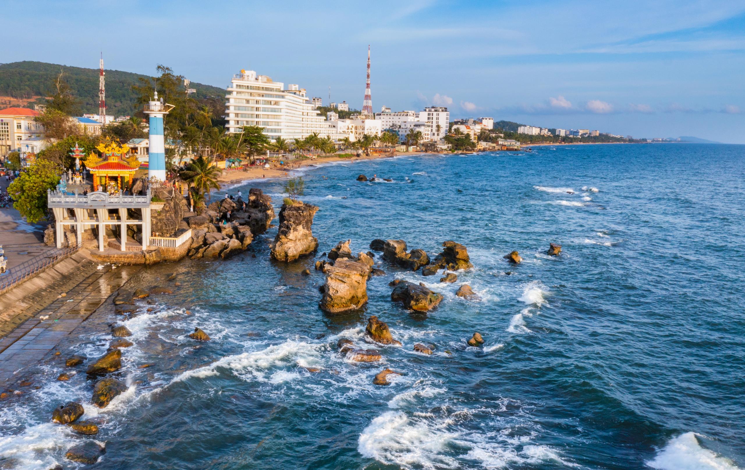 Dinh Cau shrine and striped harbour beacon on the rocky waterfront