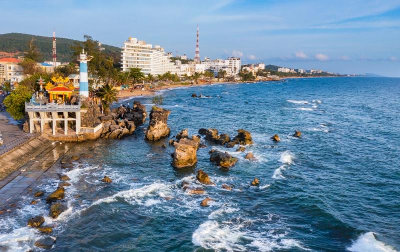 Dinh Cau shrine and striped harbour beacon on the rocky waterfront