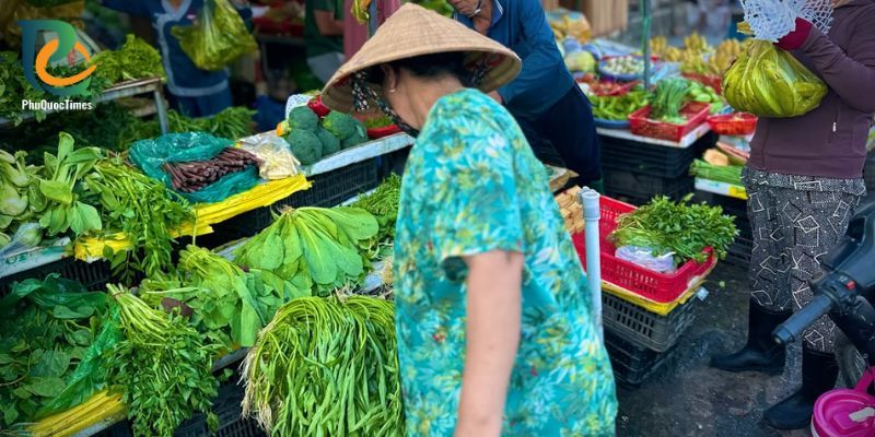 Leafy vegetables and shoppers at the Ham Ninh morning market