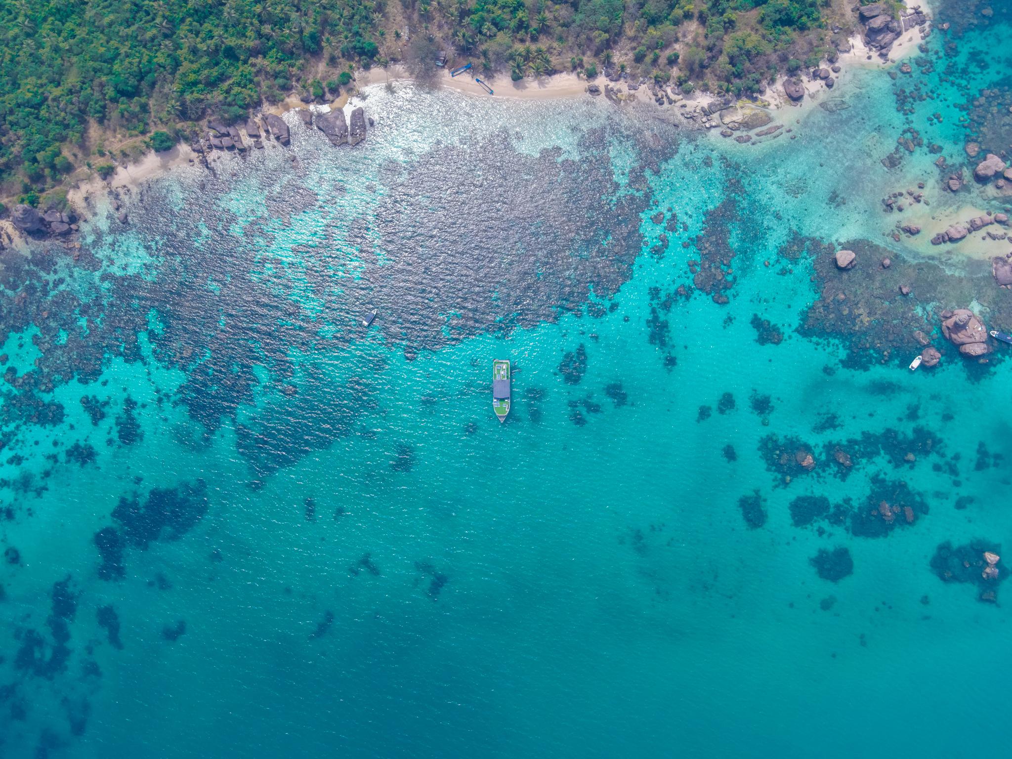 The rocky shoreline and shallow water around Gam Ghi from above