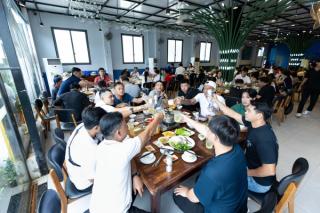 A group sharing a meal at long restaurant tables