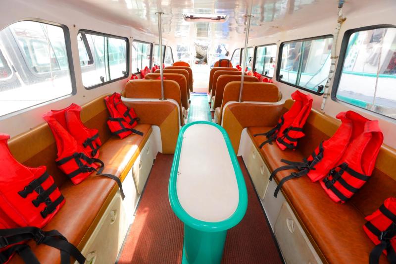 Rows of seats and orange lifejackets in a speedboat cabin