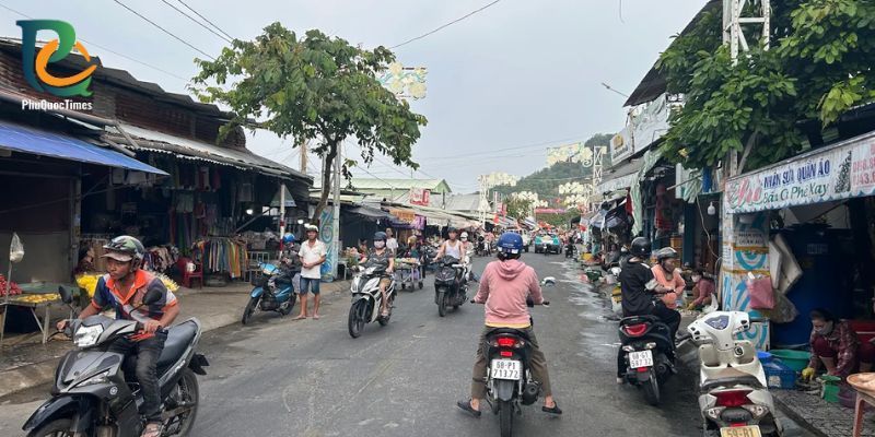 Ganh Dau market street with covered stalls and daily scooter traffic