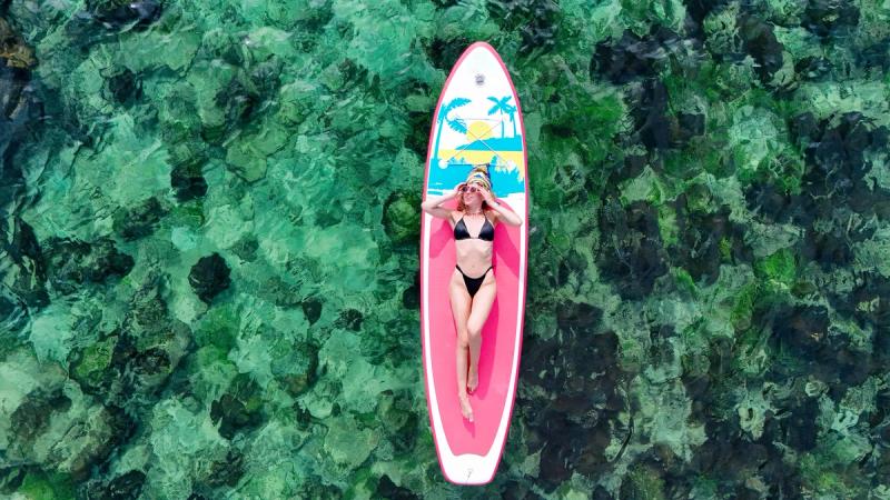 A paddleboard floating above shallow clear water