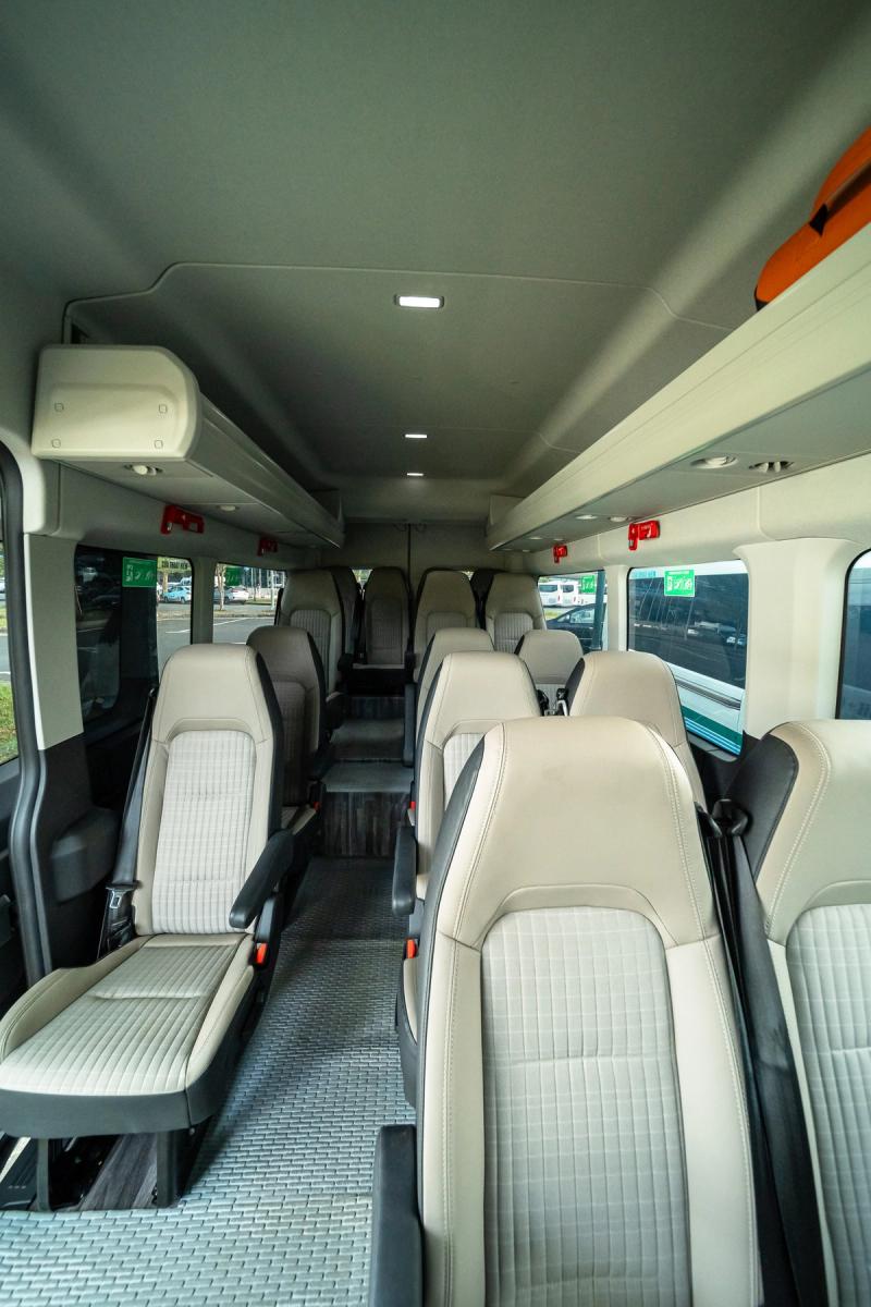 Empty minibus cabin with individual seats and a central aisle