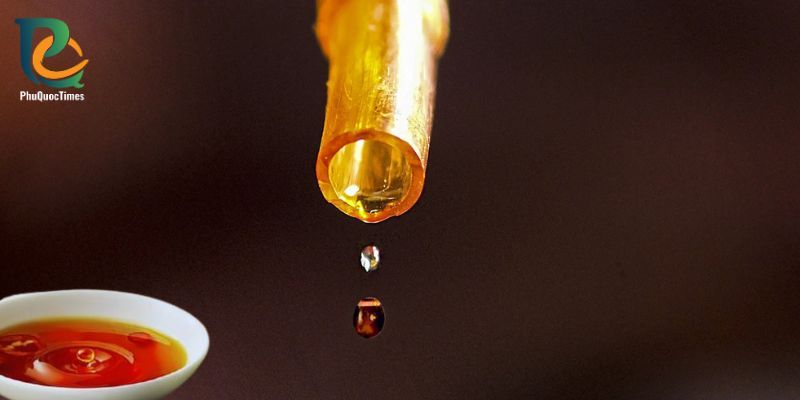 Amber fish sauce dripping into a tasting bowl