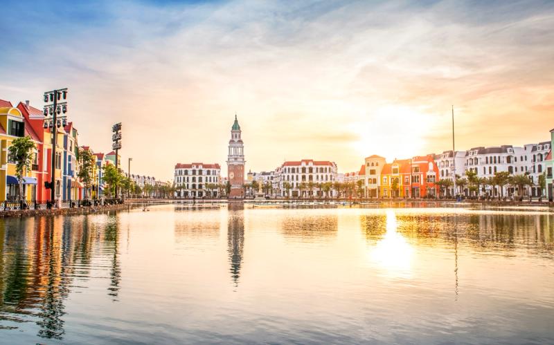 Grand World clock tower reflected in the canal at sunset