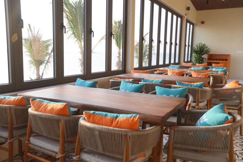 Cushioned chairs and dining tables beside the windows in the Airwaves collection