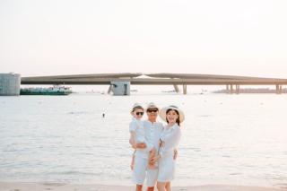 A family on the beach with Kiss Bridge behind them