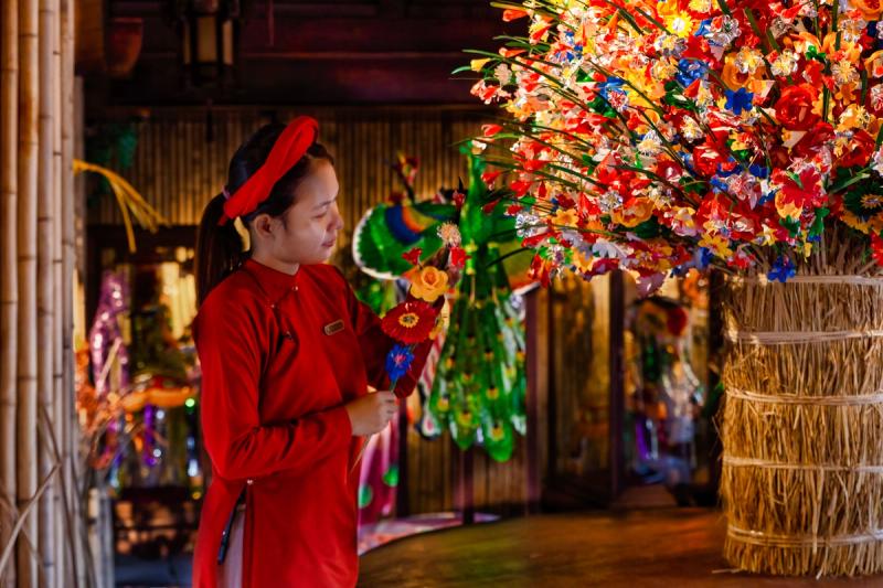 A person beside a colourful paper-craft display