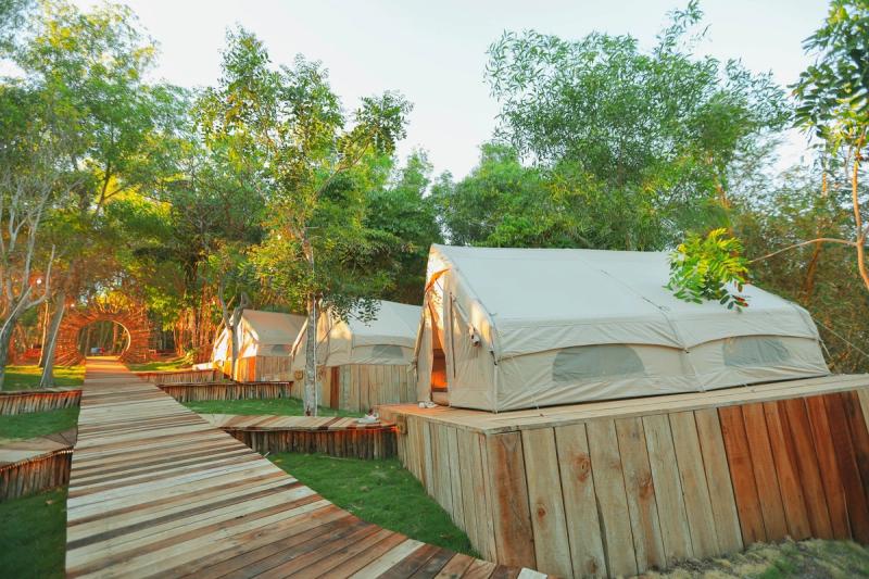 Canvas tents on raised platforms beside a wooden walkway