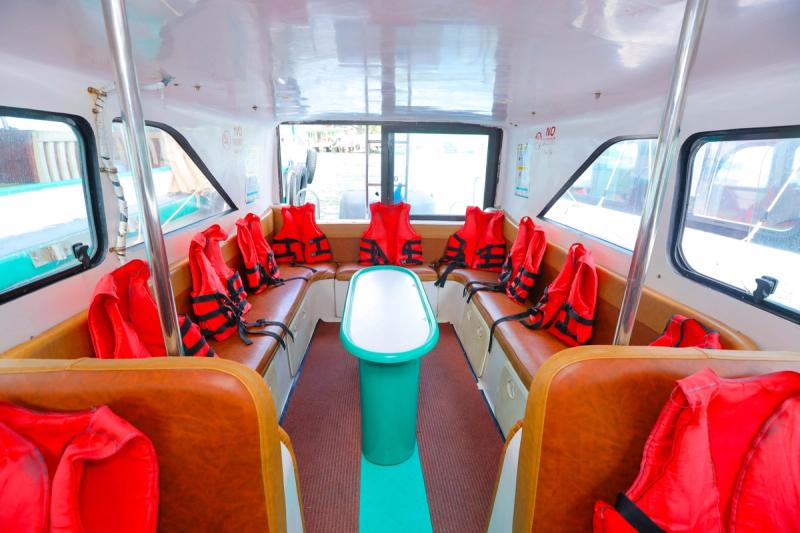 Rows of seats and orange life jackets inside a speedboat cabin