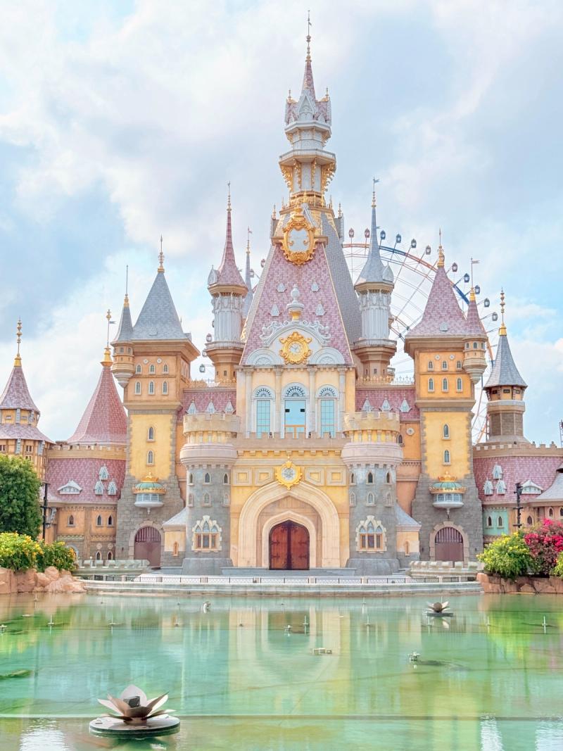 The fairytale castle and its lake at VinWonders Phu Quoc in daylight.