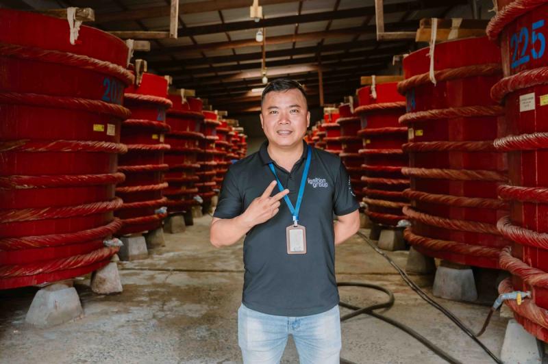 Rows of large wooden barrels inside a fish-sauce facility