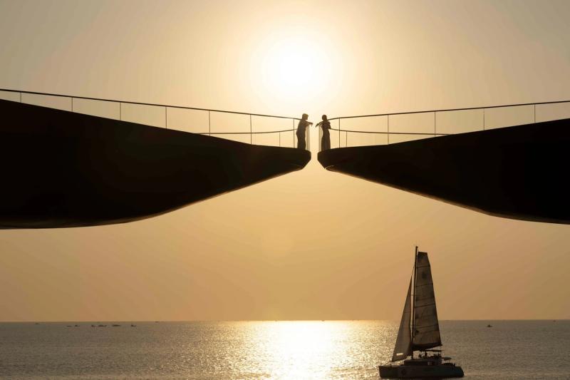 Sailboat beside Kiss Bridge at sunset