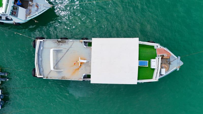 Tour boat seen from above with a central roof and open deck areas